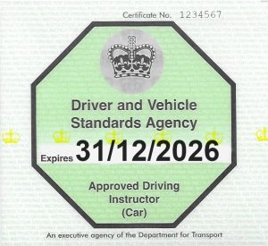 A fully-qualified driving instructor's badge in green, with an octagonal symbol and expiry date