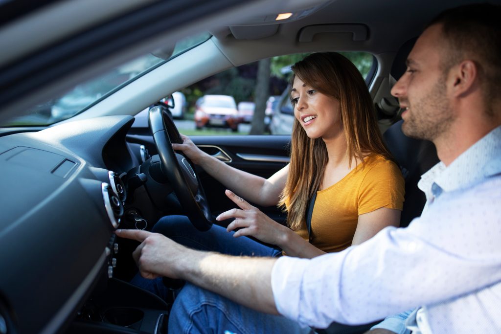 A couple learning the controls of a car