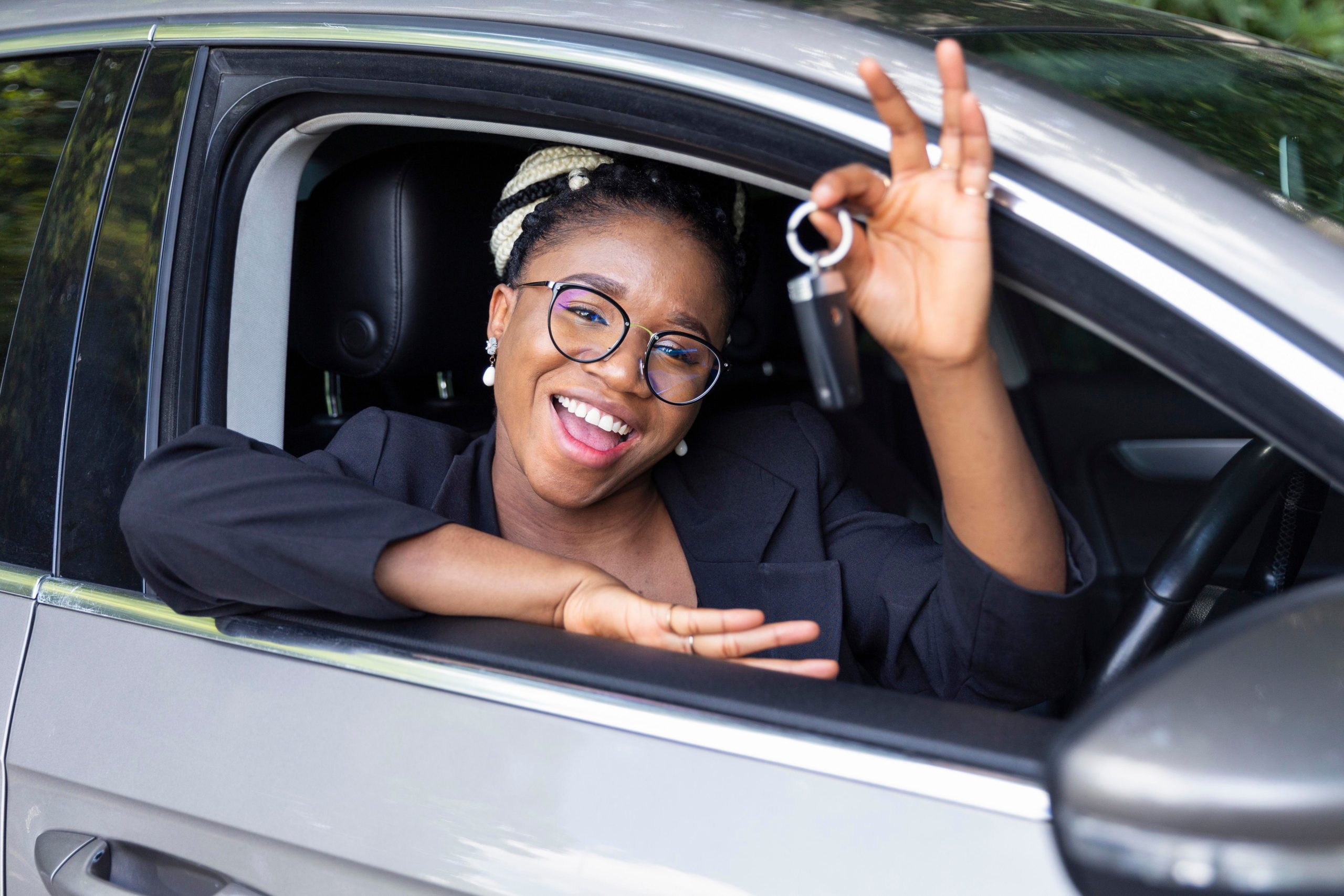 A young female excitedly showing the keys to her new car